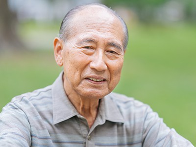 A portrait of a senior adult man outdoors.