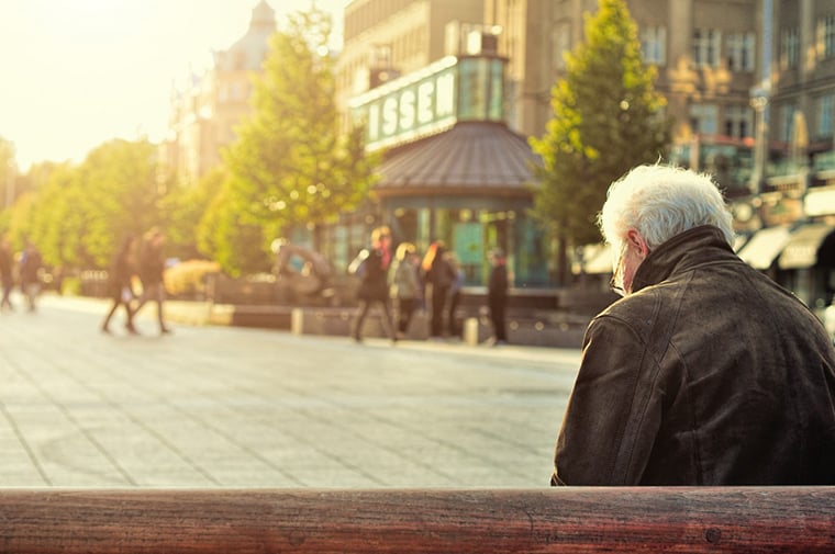 elderly man on bench outdoors.